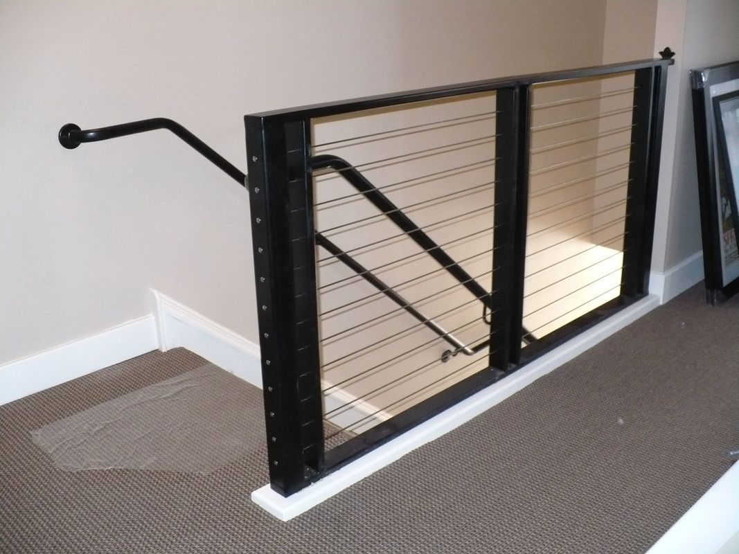 A staircase with a railing and a carpeted floor