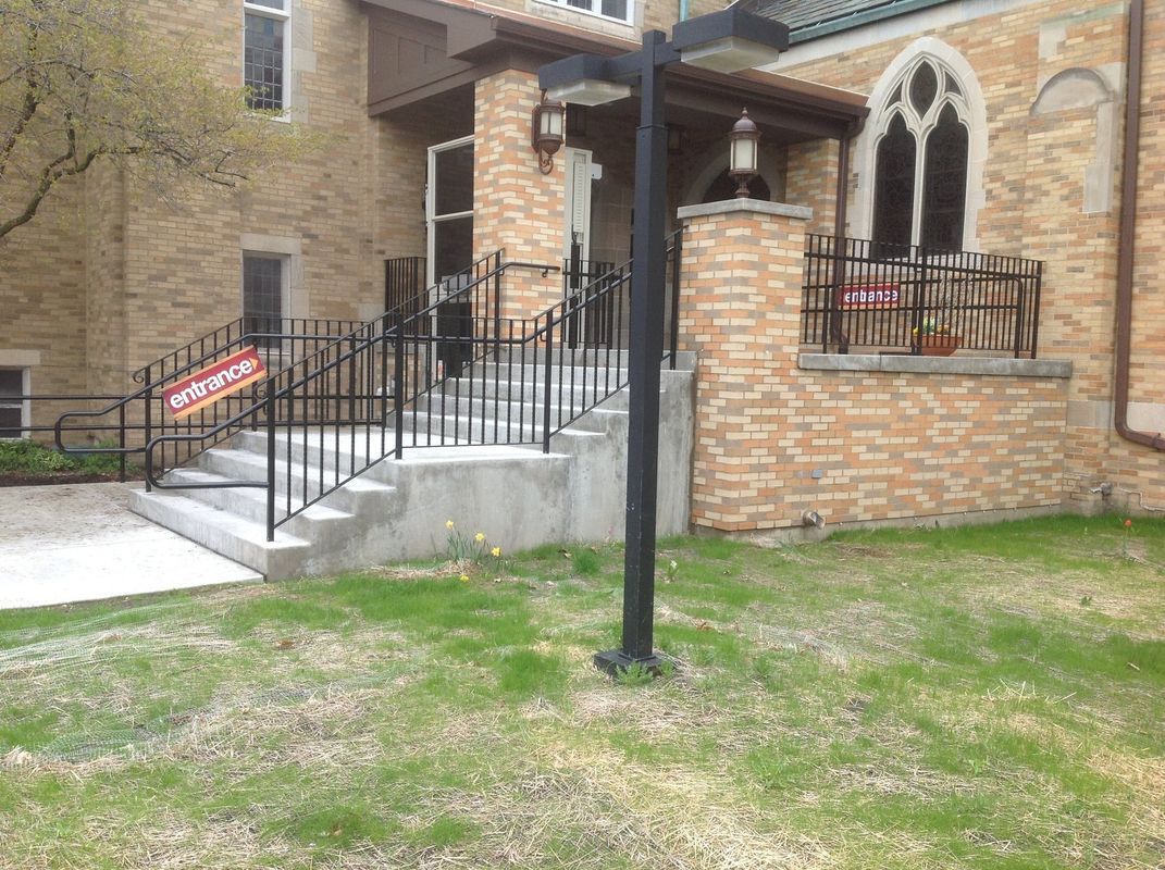 A brick building with stairs and a sign that says no parking