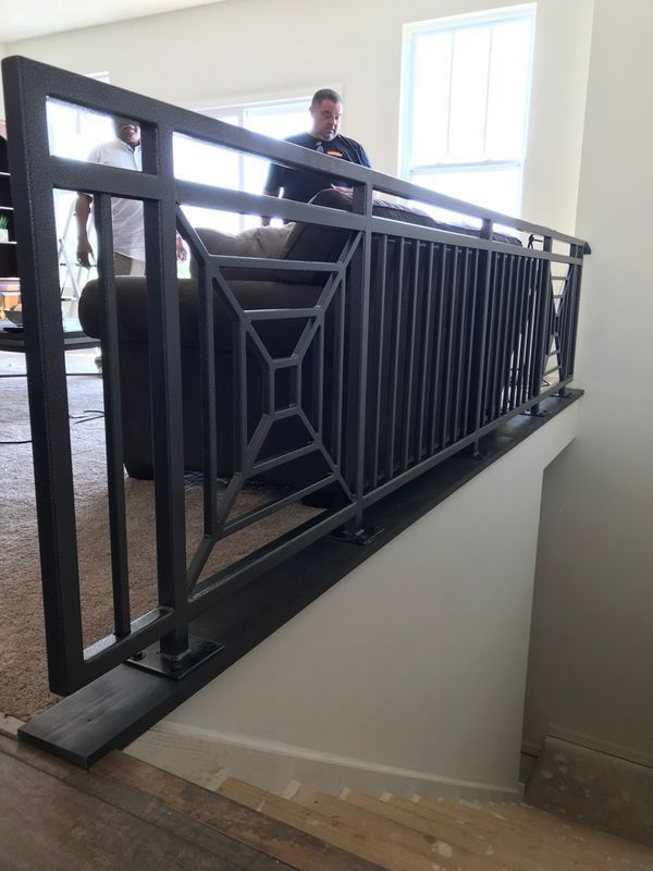 A man sits on a couch behind a railing in a living room