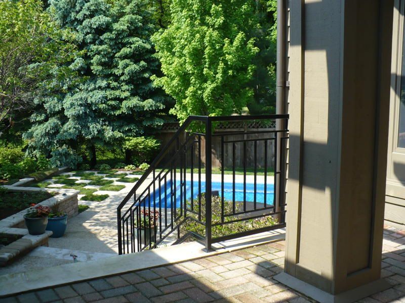 A patio with stairs leading up to a pool