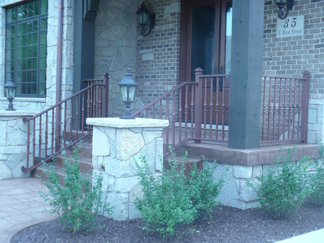A brick house with a porch and stairs