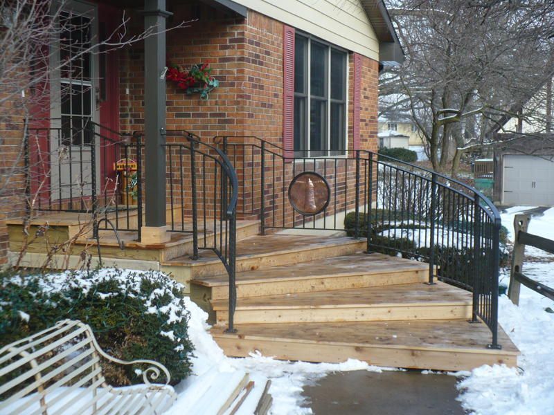 A brick house with wooden steps and a metal railing