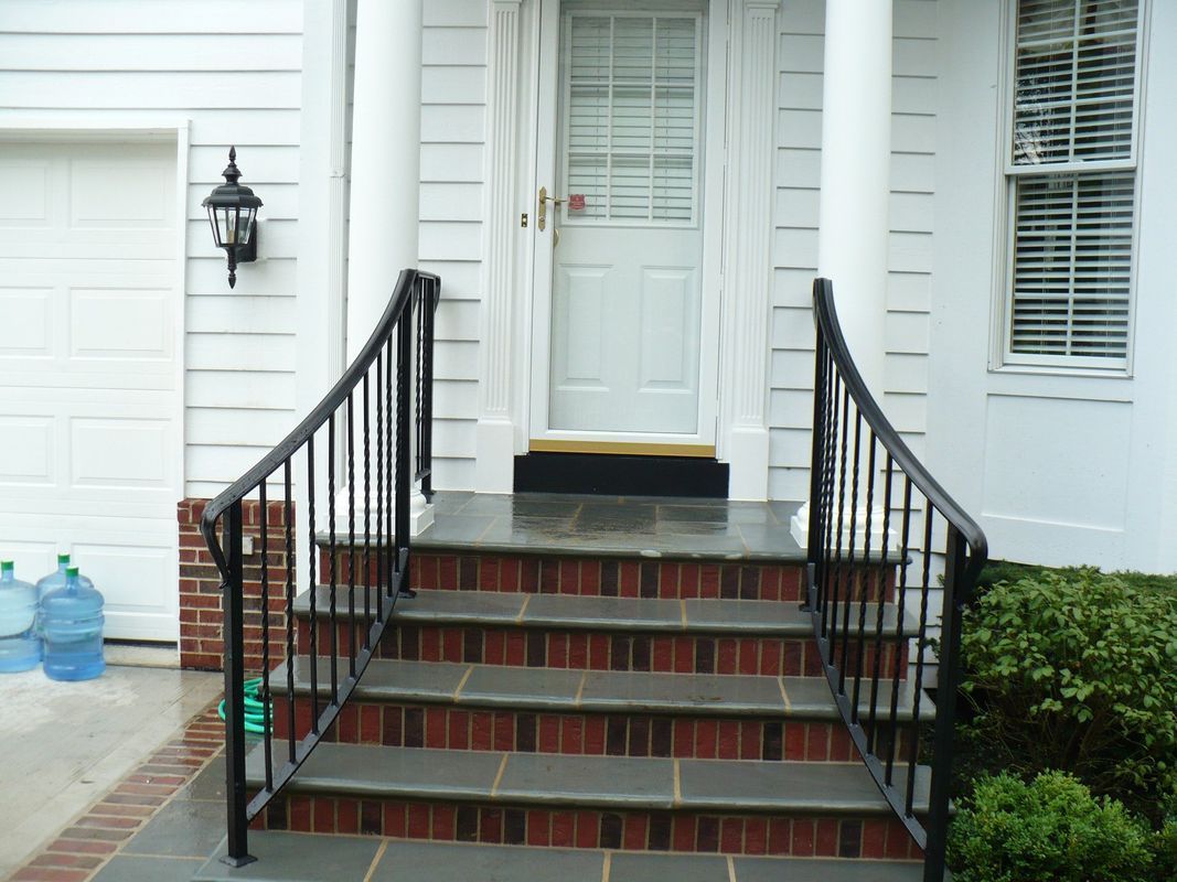 A white house with stairs leading up to the front door