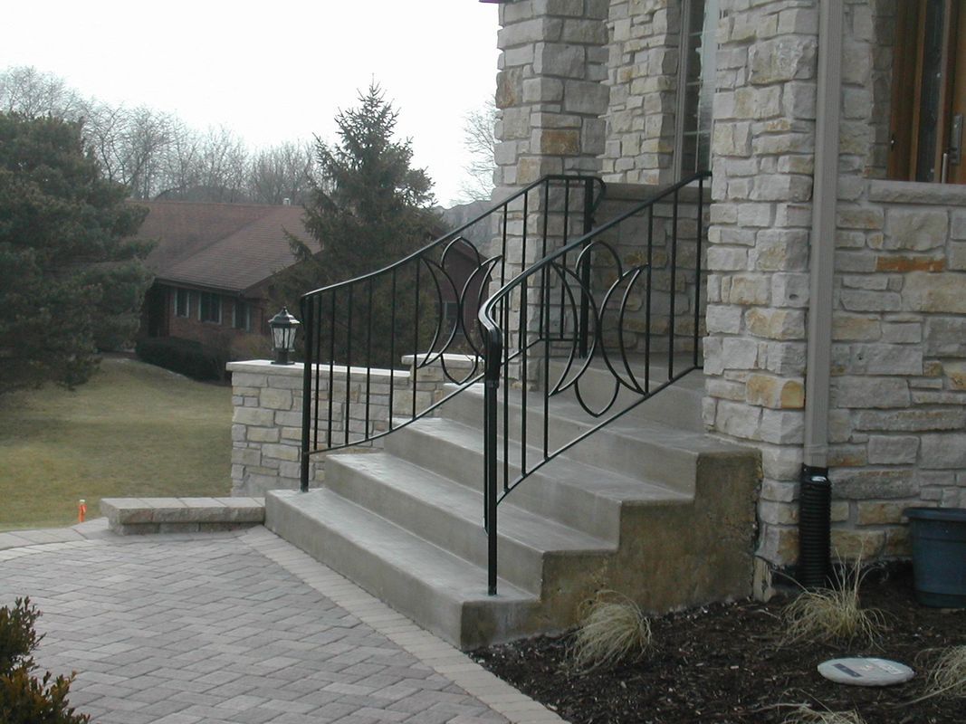 A stone building with stairs and a wrought iron railing