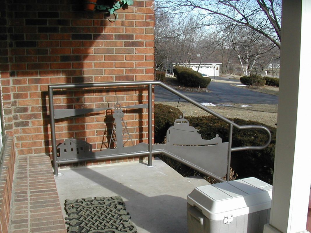 A porch with a metal railing and a cooler