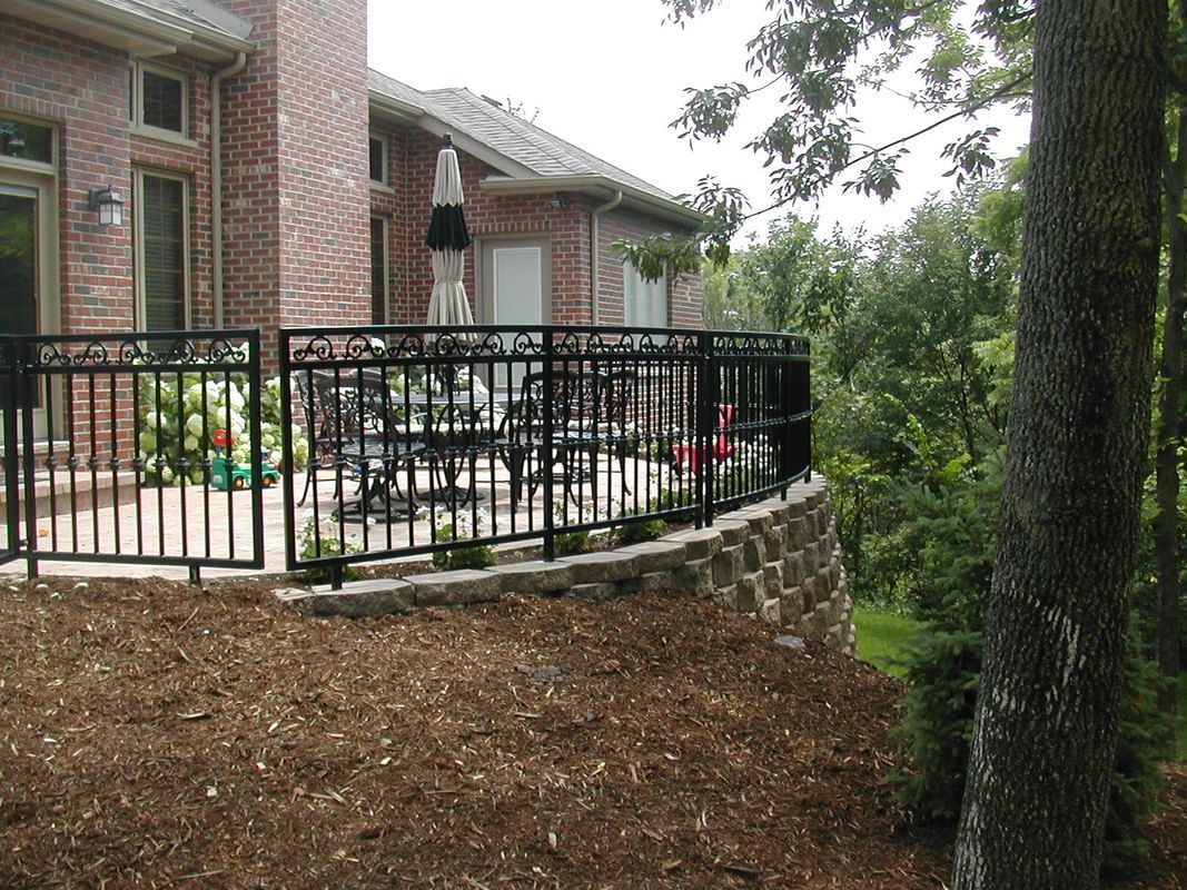 A brick house with a deck and a fence around it