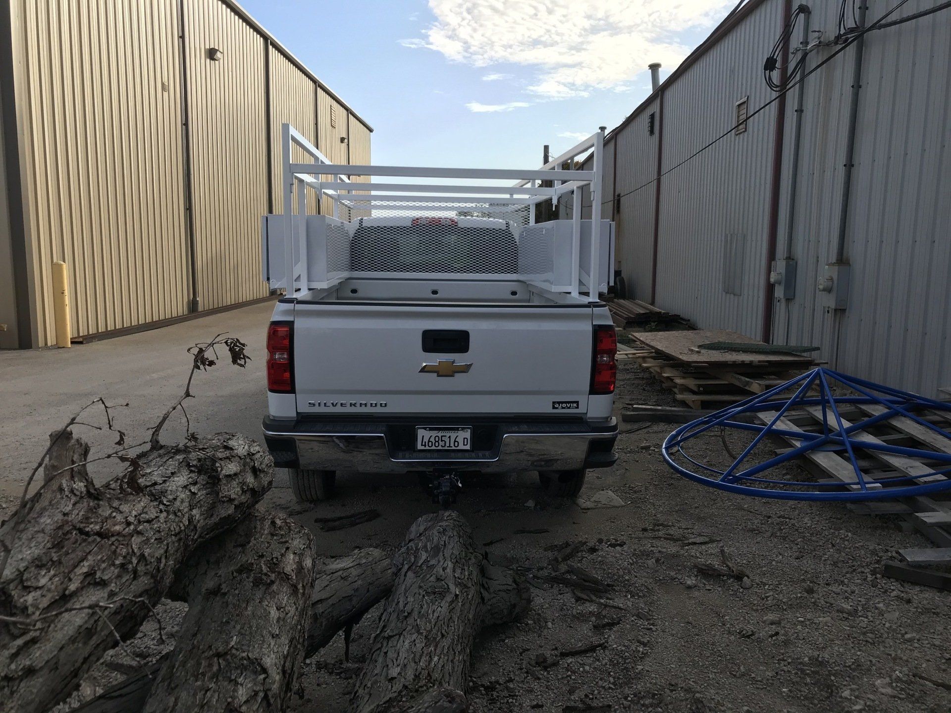 A white truck with a ladder rack on the back of it