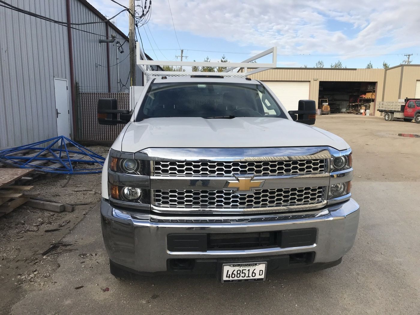 A white truck is parked in front of a building.