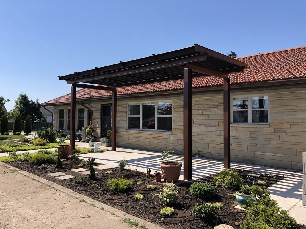 A house with a pergola on the front of it.