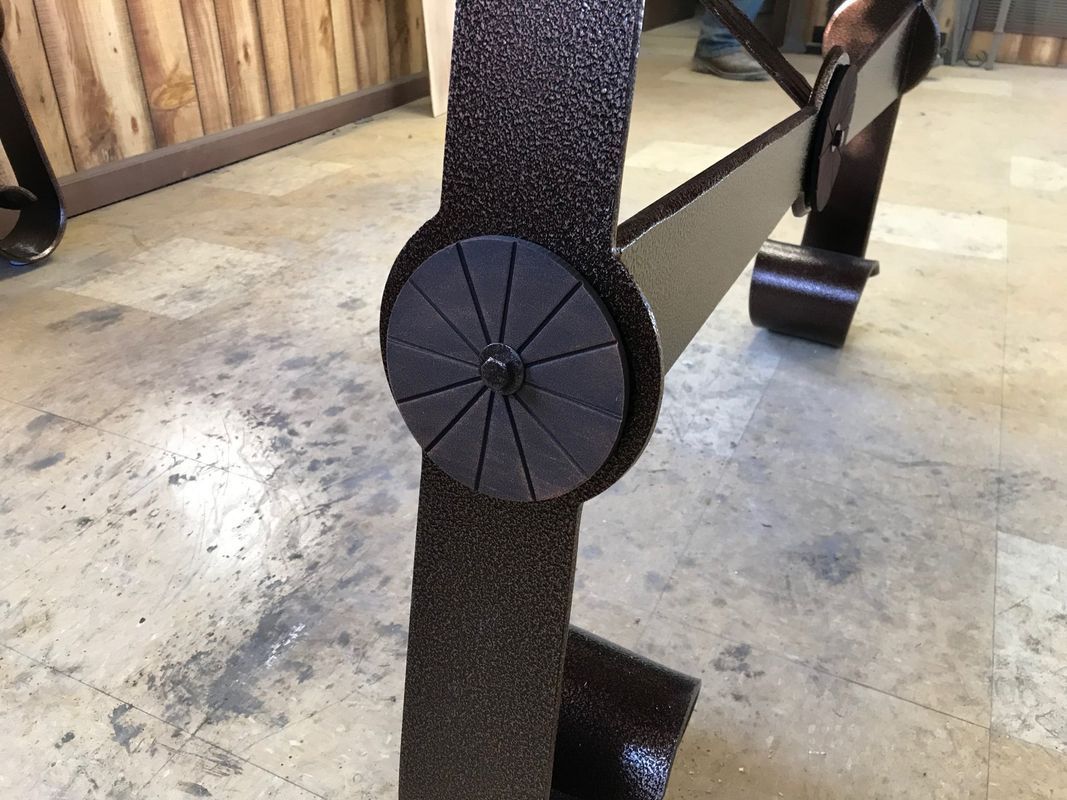 A person is standing next to a table with a wheel on it.