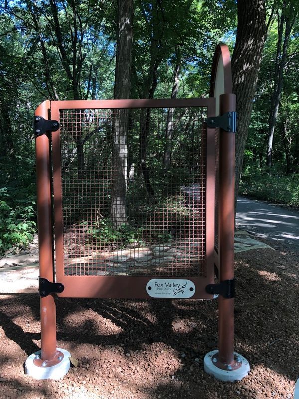 A wooden gate in the middle of a forest