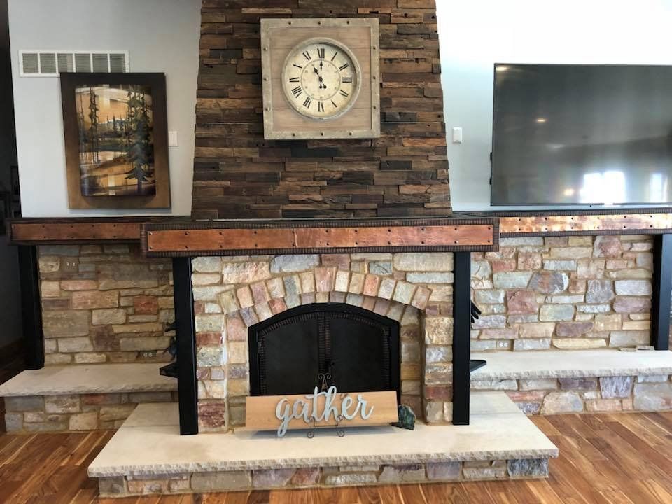 A fireplace with a clock above it and a sign that says gather