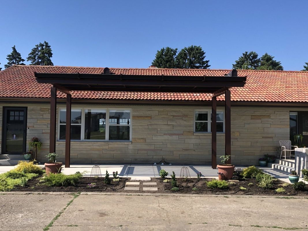 A house with a pergola on the front of it