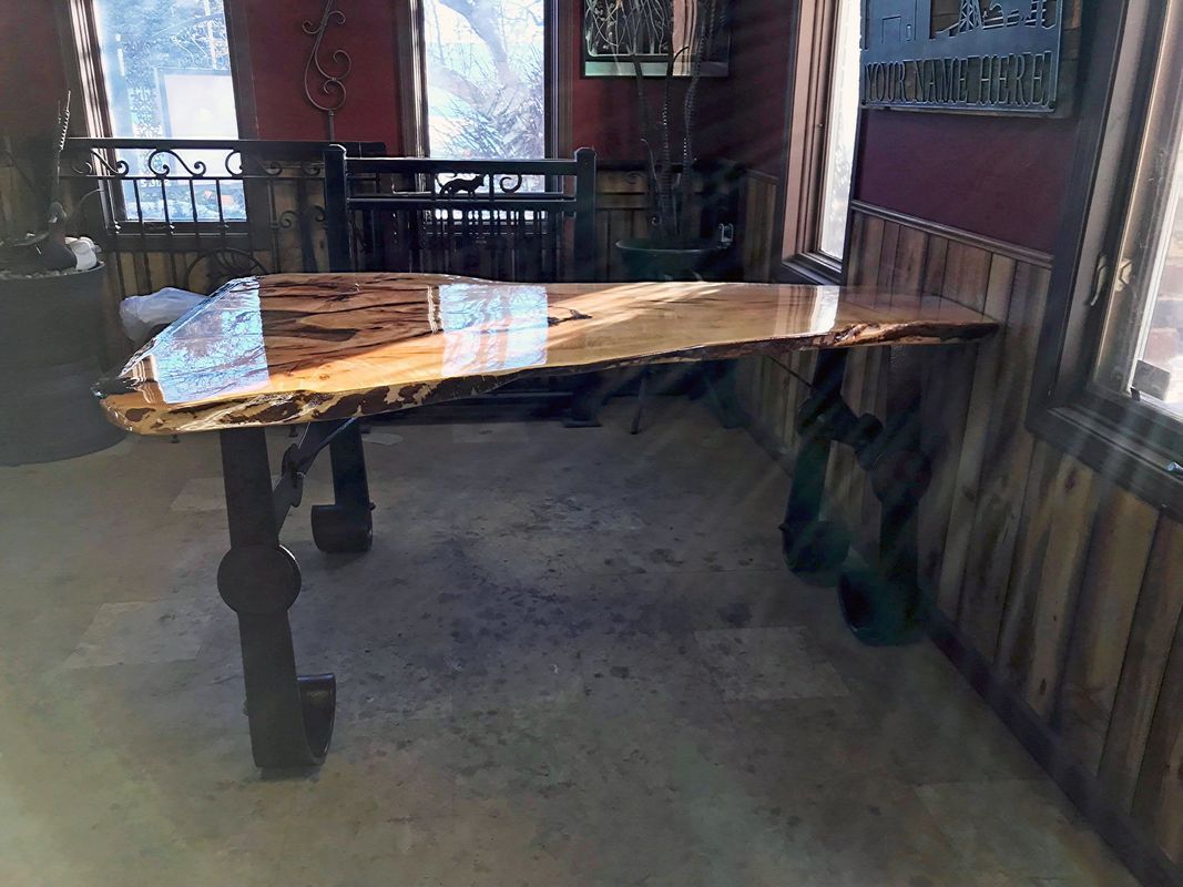 A wooden table is sitting in a room next to a window.