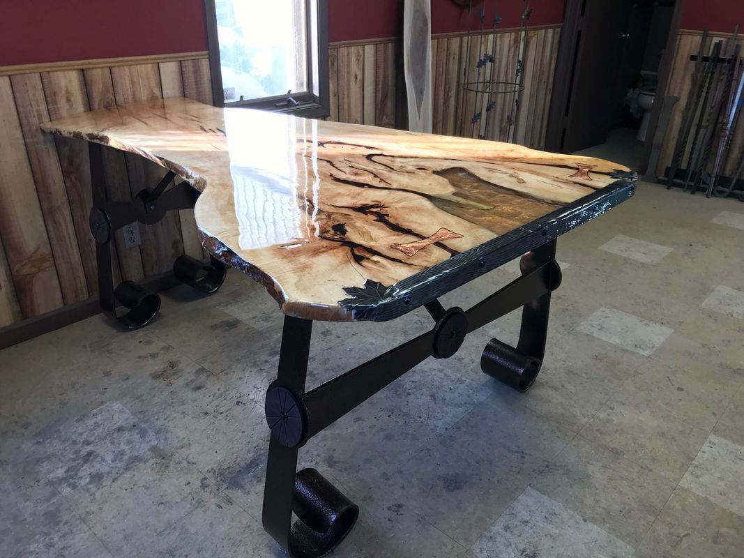 A wooden table is sitting in a room next to a window.