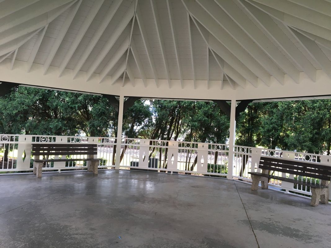 An empty gazebo with two benches underneath it