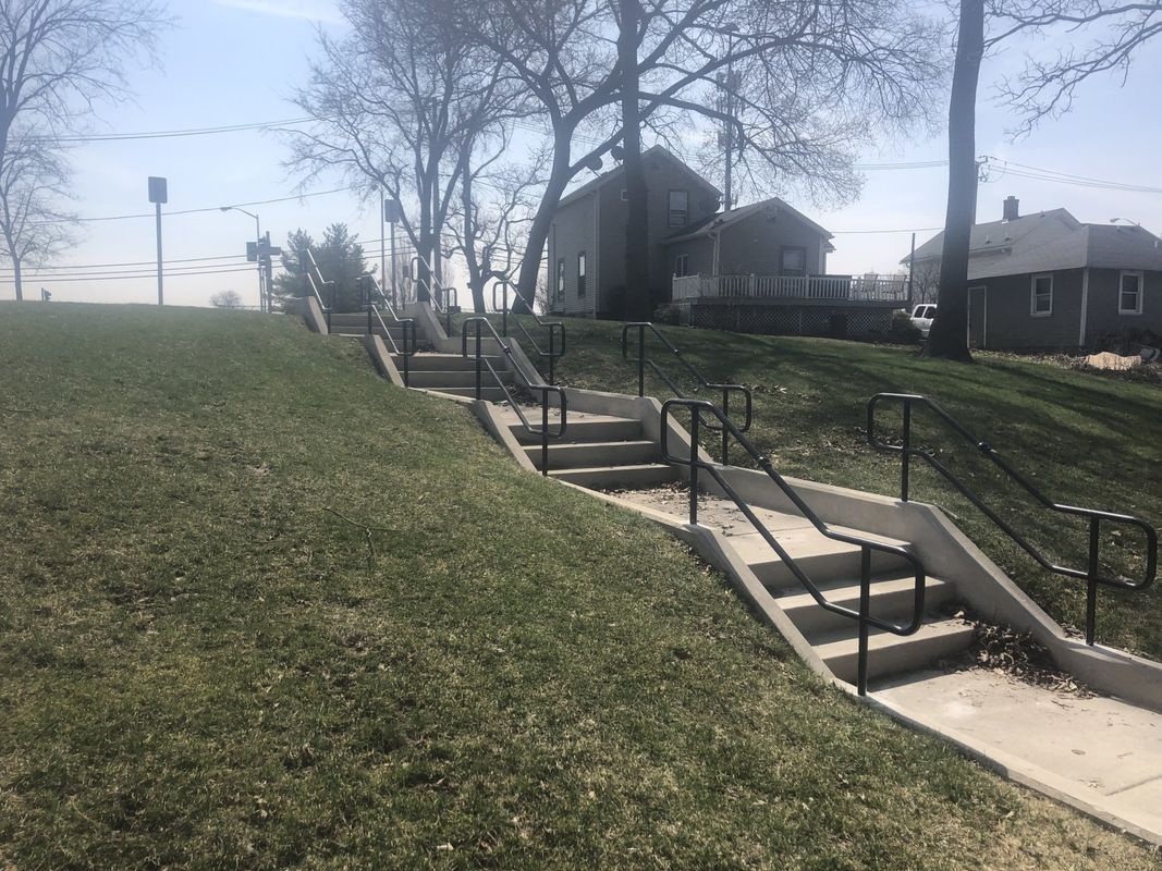 A row of stairs leading up to a grassy hill.
