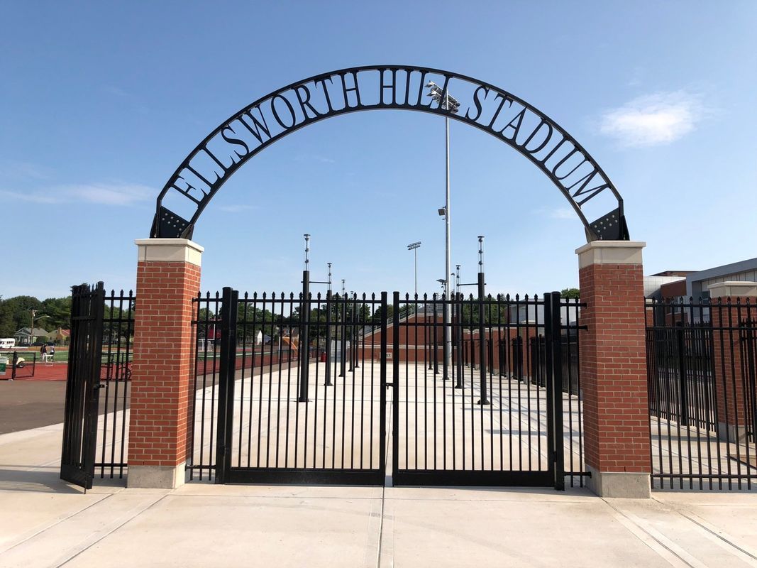 A gate with a sign that says hill short stadium