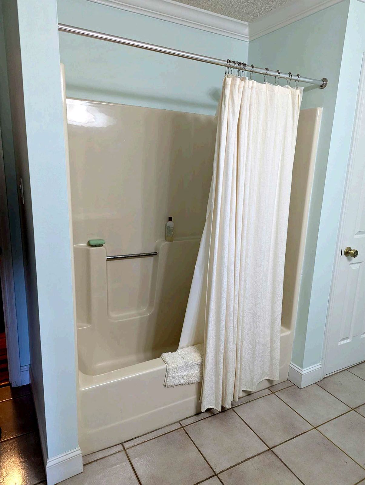 An old bathroom with a tub and shower with a shower curtain