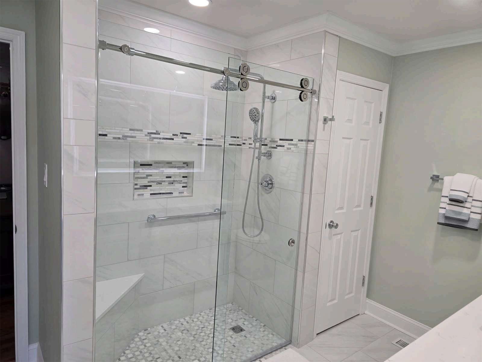 A newly remodeled bathroom with a walk-in shower with a sliding glass door