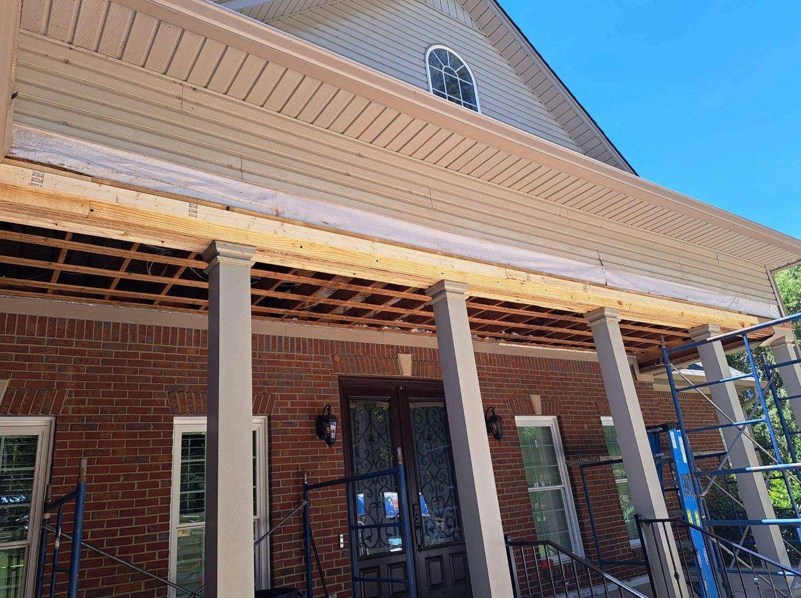 A brick house with a porch under construction.