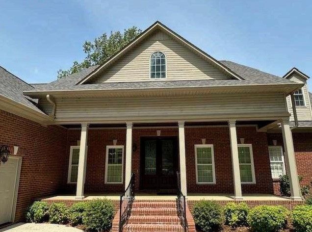A large brick house with a porch and stairs