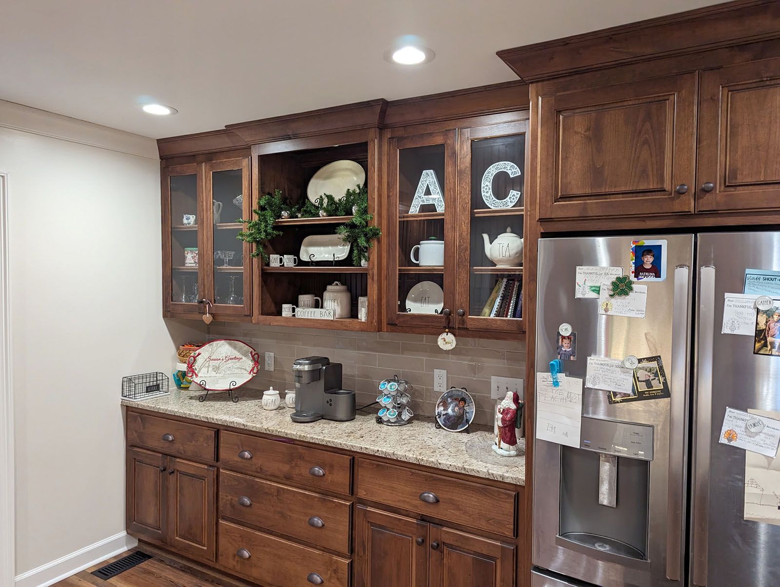 A kitchen with stainless steel appliances and dark wooden cabinets