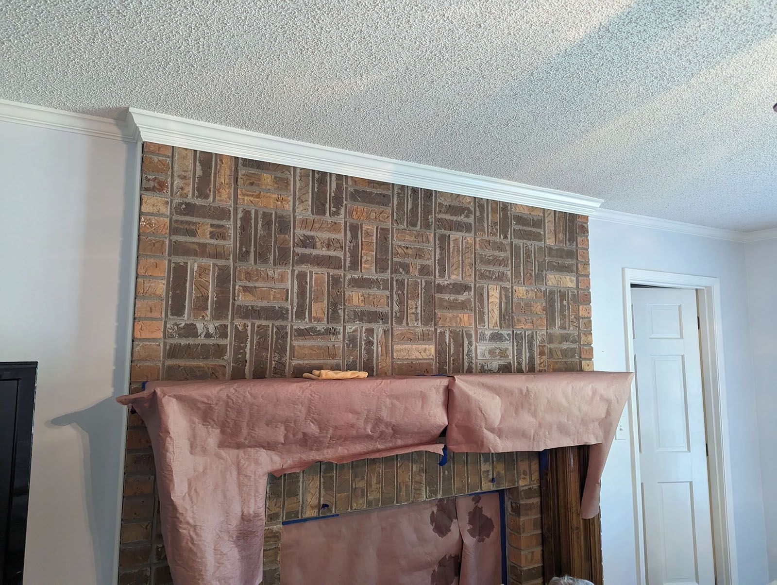 A living room with a fireplace and a brick wall