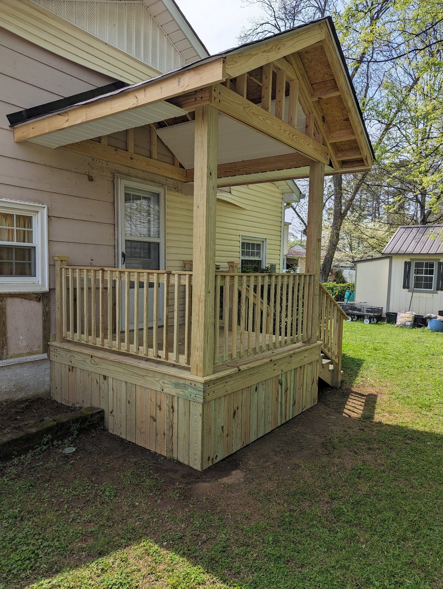 A wooden porch is being built on the side of a house.