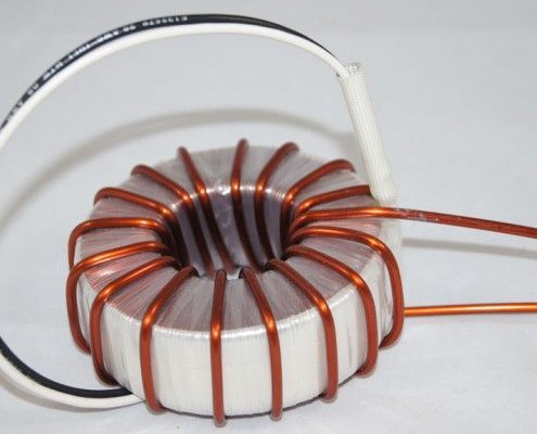 A close up of a coil with copper wires on a white surface