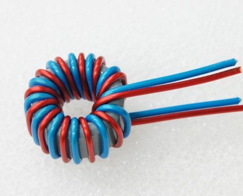 A close up of a red and blue coil on a white surface
