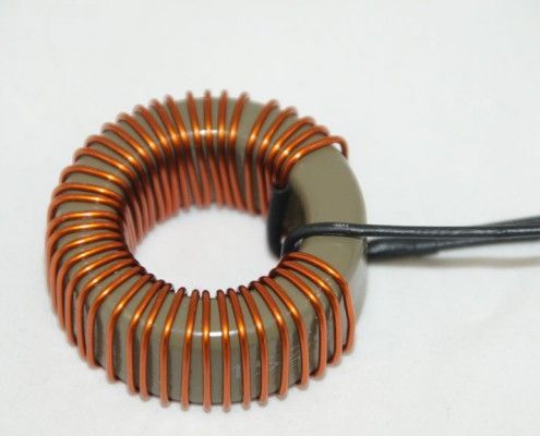 A close up of a copper wire coil on a white surface