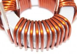 A close up of a copper wire coil on a white surface.
