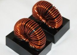Two copper coils are sitting on top of each other on a white surface.