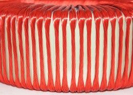 A close up of a red and white striped object on a white surface.