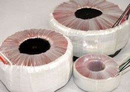 Three transformers are sitting on top of each other on a table.