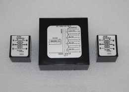 Three black boxes with white labels on them are sitting on a table.