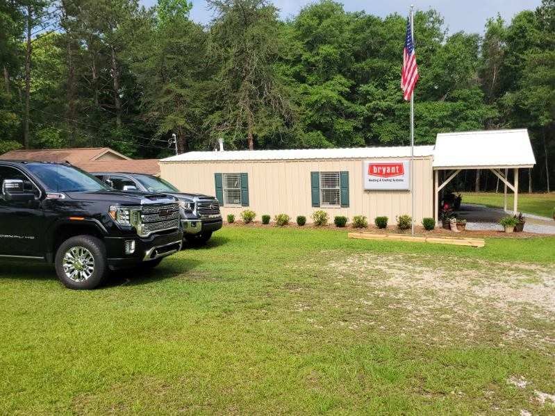 Two trucks parked outside a small building with an American flag.