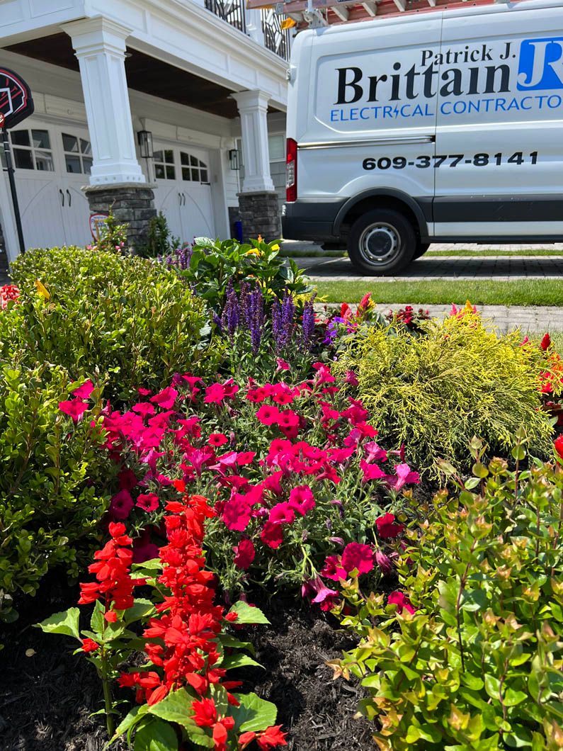 Colorful flower bed in front of a building and parked van with a Britt sign.