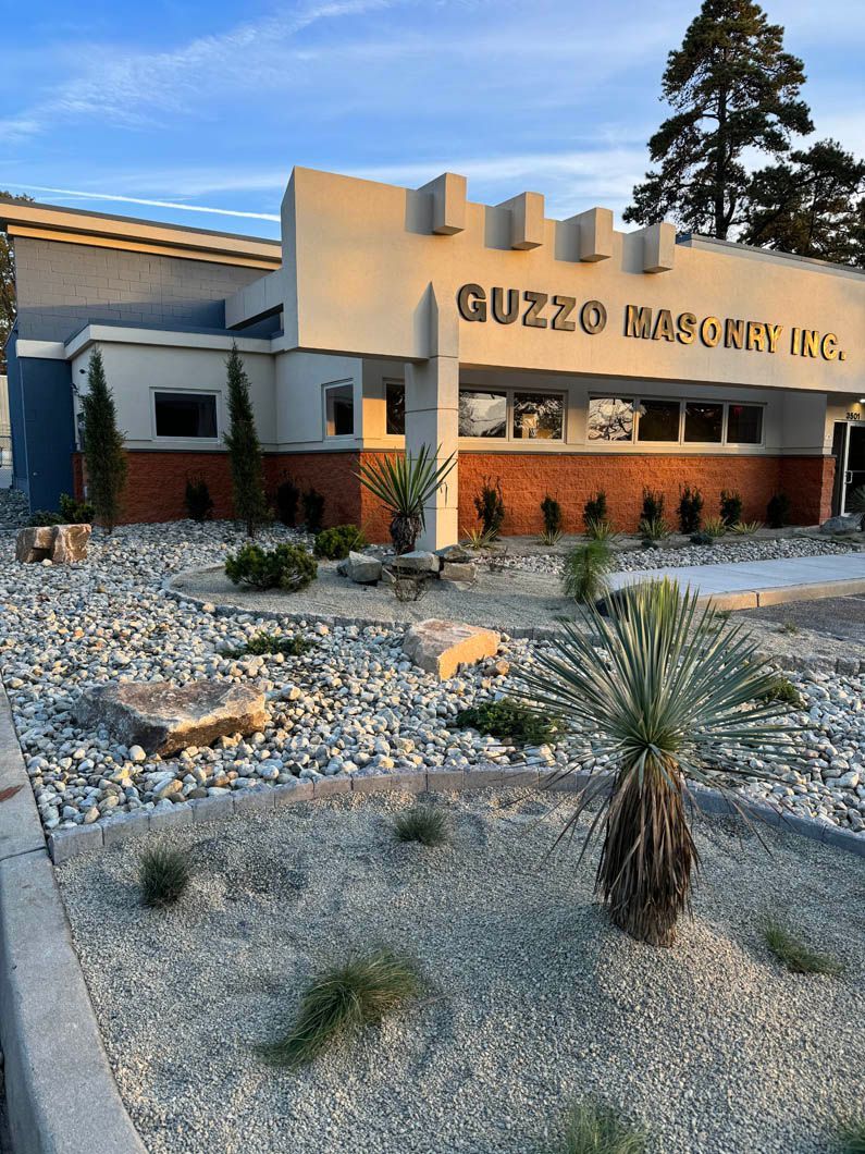 Modern office building with desert landscaping and a sign reading “Muzzo Insurance Co.”