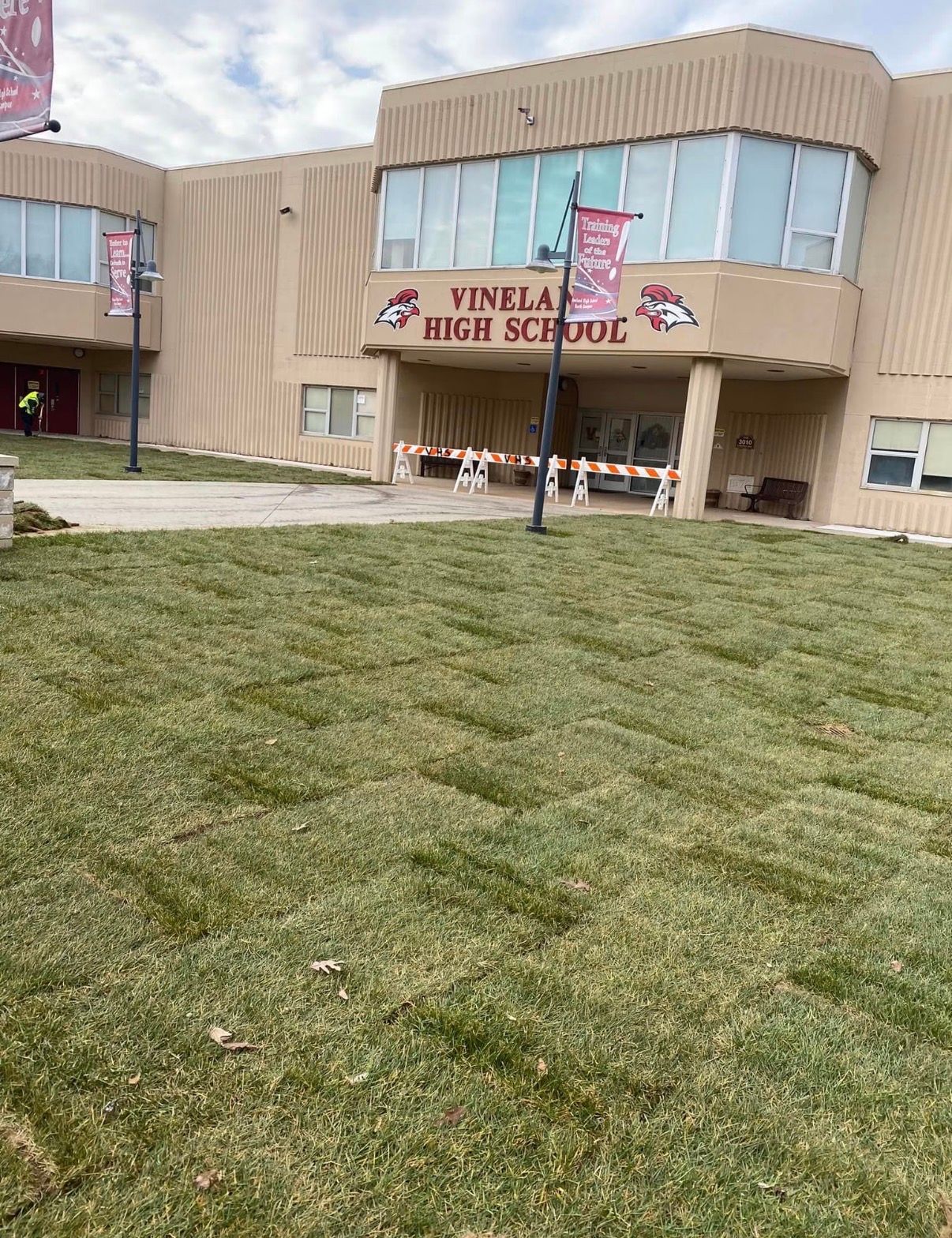 Front entrance of Finley High School, tan building with a grassy lawn in front.
