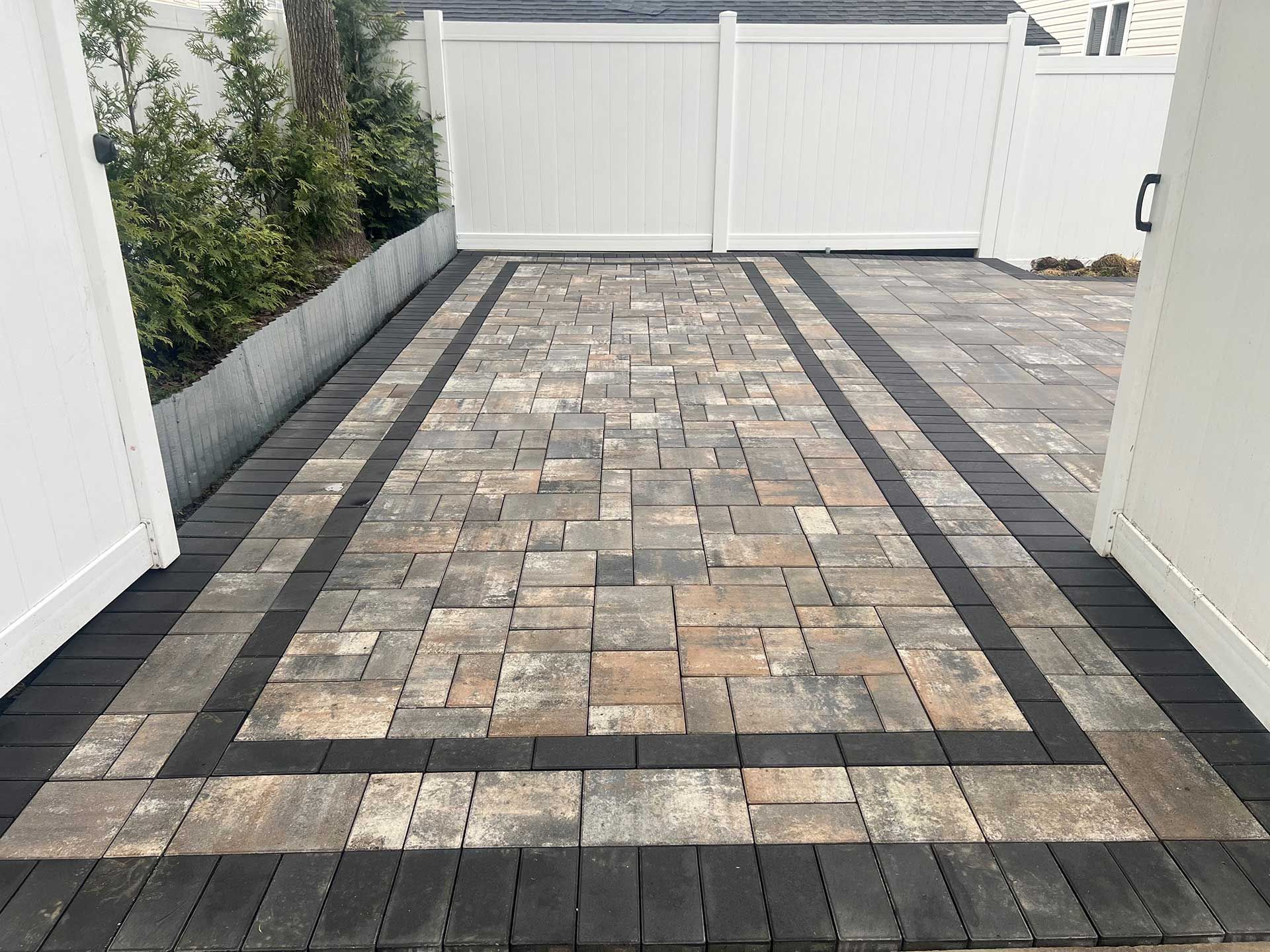 A patio with a white fence in the background