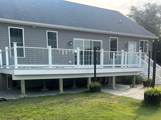 The back of a house with a large deck and stairs.