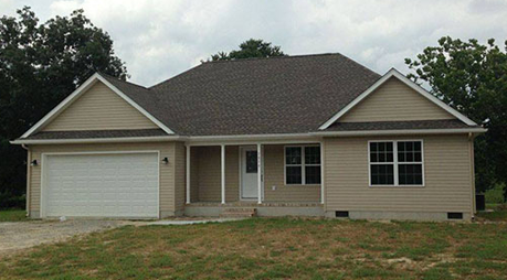 A house with a gray roof and a white garage door