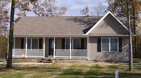 A house with a porch and trees in the background