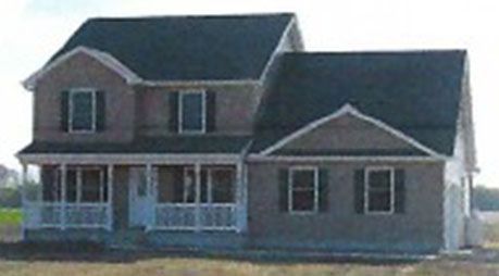 A picture of a house with a porch and a black roof.