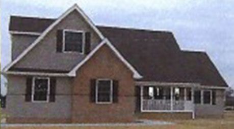 A brick house with a brown roof and white trim