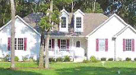 A row of white houses with red shutters on the windows