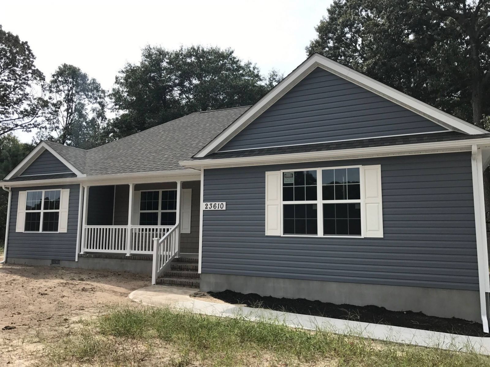 A blue house with a white porch and a gray roof