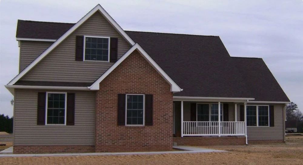 A house with a porch and a brick wall
